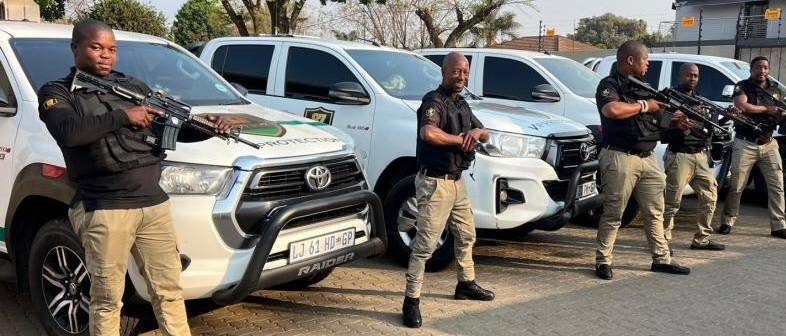 Armed response officers standing beside VIP protection vehicles