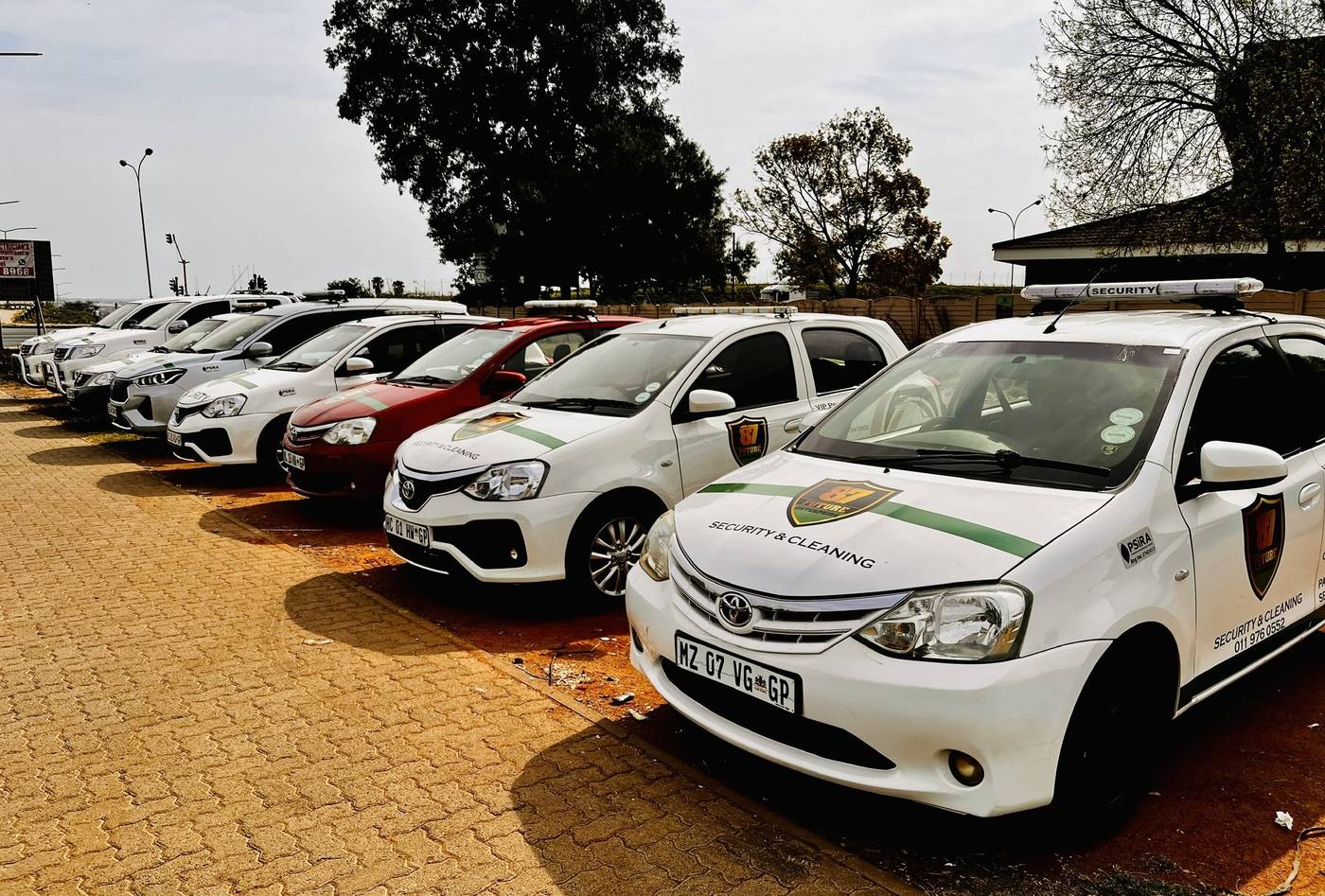 Branded sedans and bakkies parked in a row